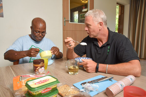 Cliënt en begeleider eten samen aan tafel