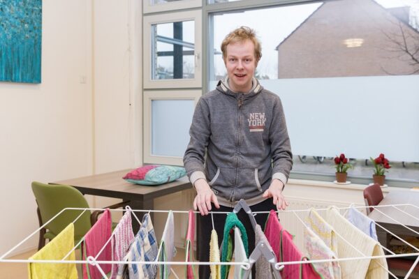 Cliënt hangt de was op tijdens dagbesteding